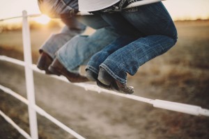 Cowboy boots on fence.