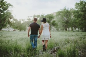 Engaged couple walking in field